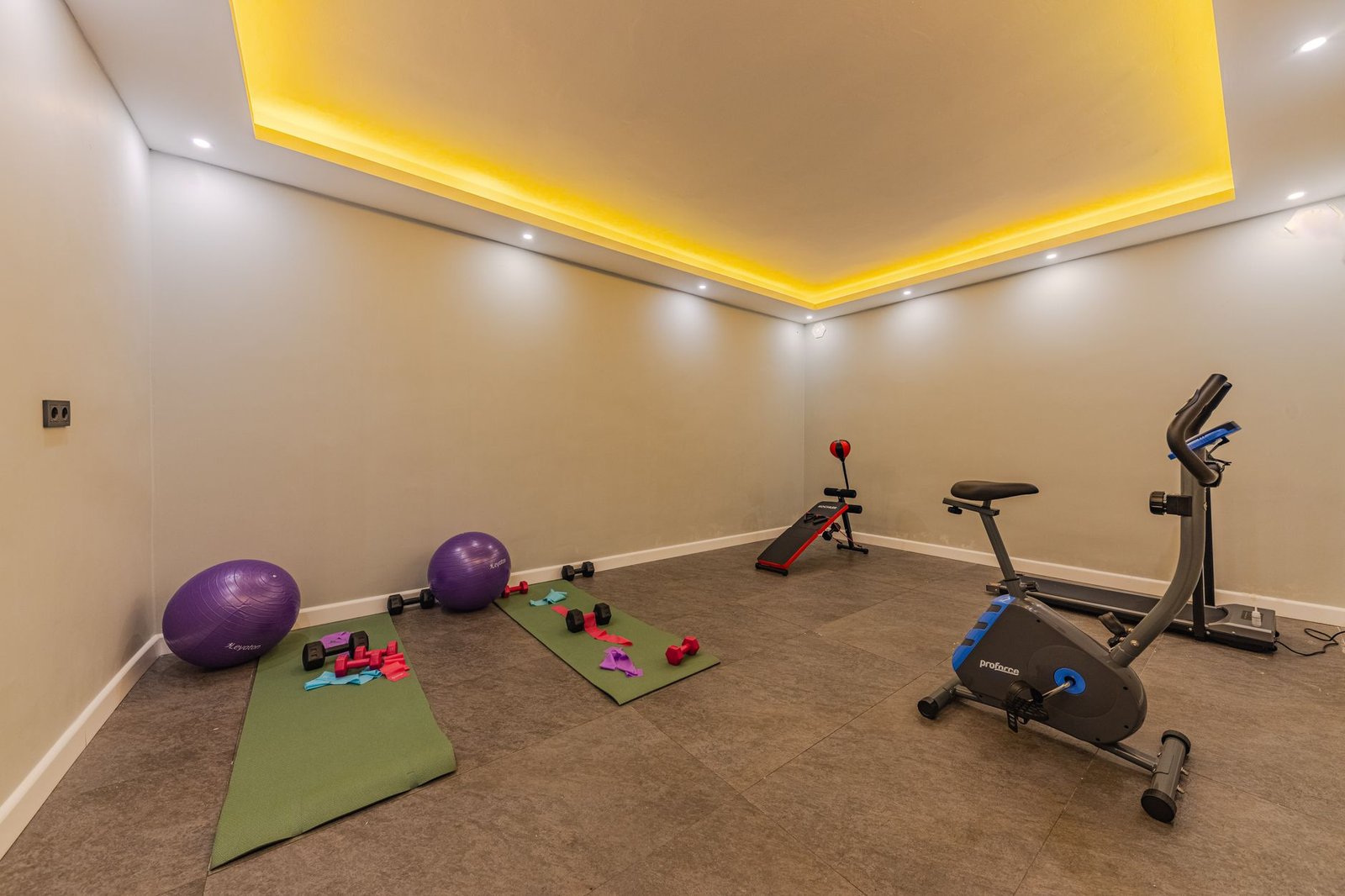 a gym room with exercise equipment and a ceiling light