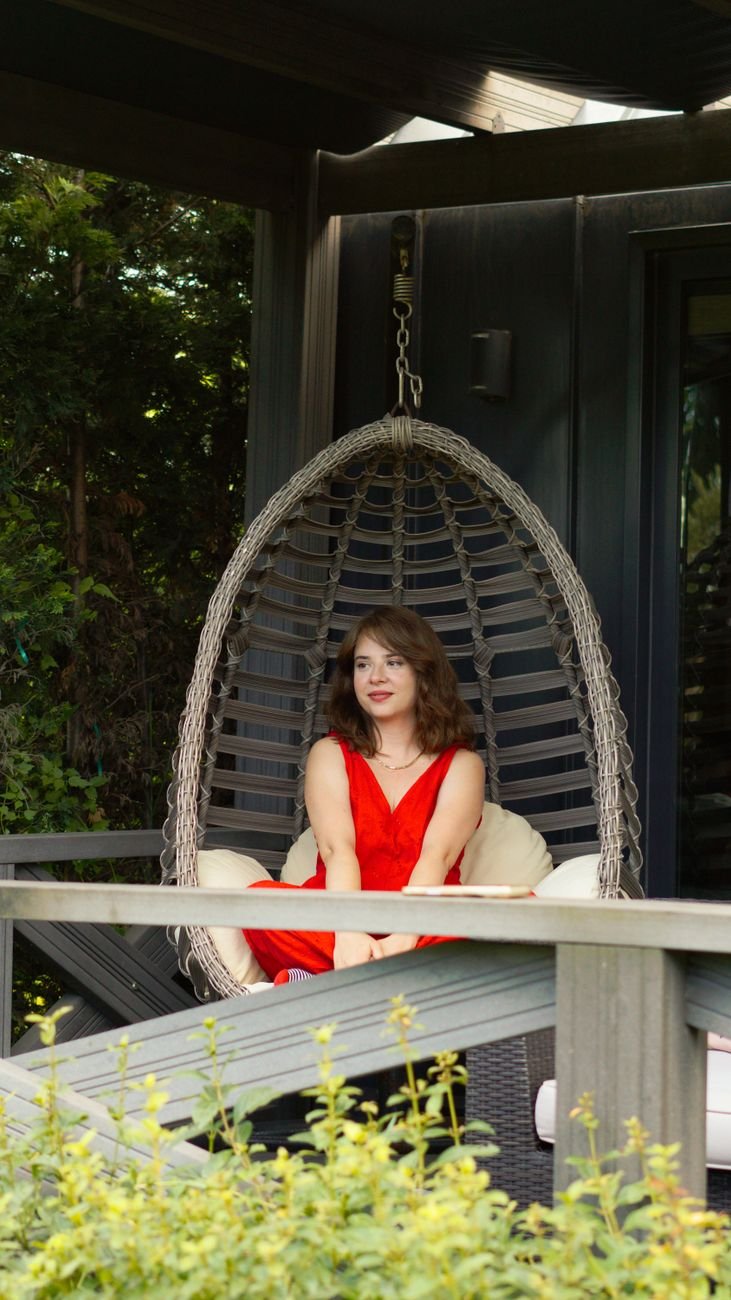 relaxing woman in red dress on porch swing chair